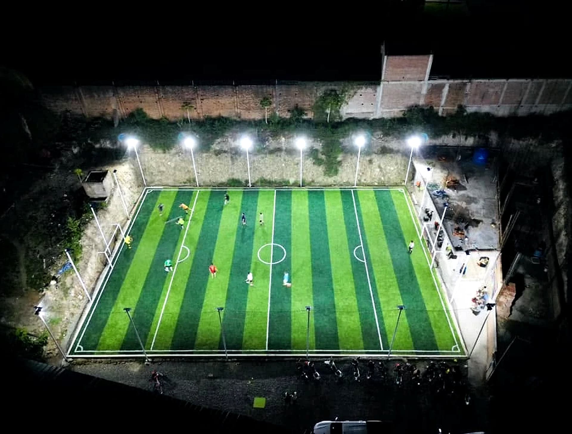 Vista aérea nocturna de la cancha sintética La Premier iluminada